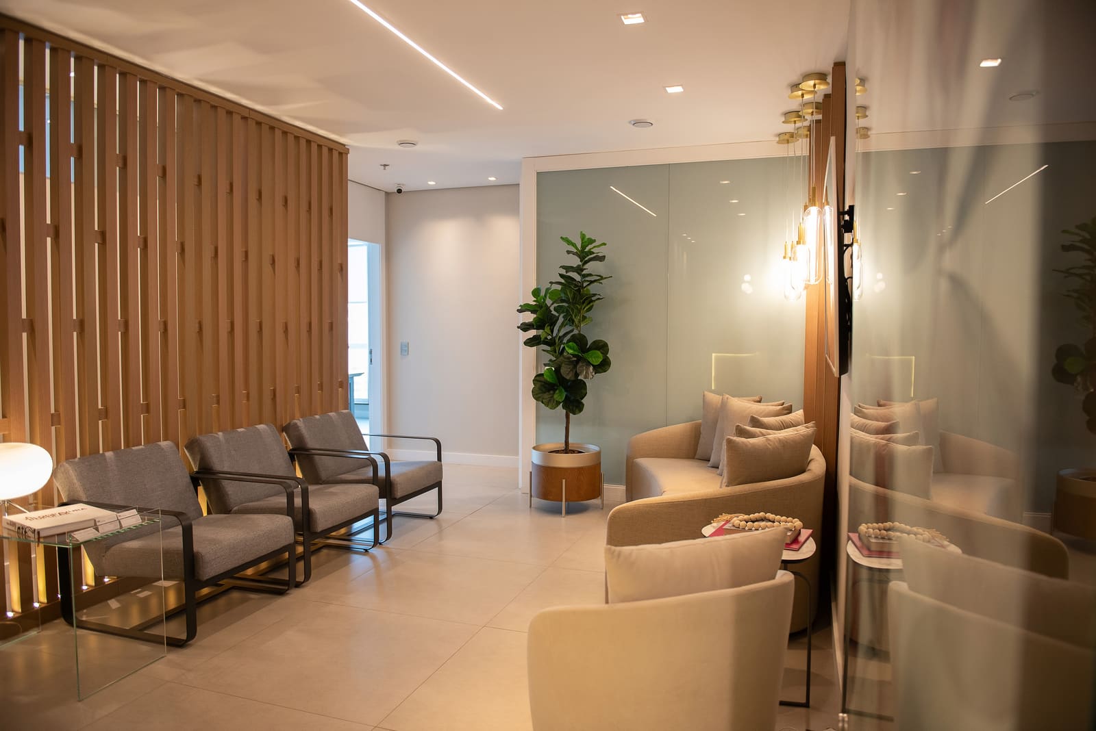 Sala de espera da Clínica Eredità na Rua Funchal, com poltronas, jardim vertical e iluminação acolhedora